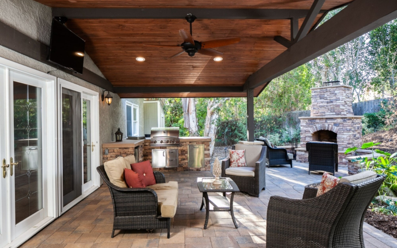 Backyard patio cover in Orange County decorated for outdoor Thanksgiving with dining table, fall décor, string lights, and heaters