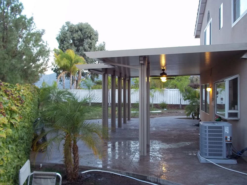 Custom Alumawood solid patio cover attached to home creating a cool and shaded outdoor space